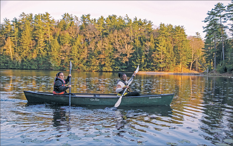 Two paddlers on a wooded lake near Oneonta